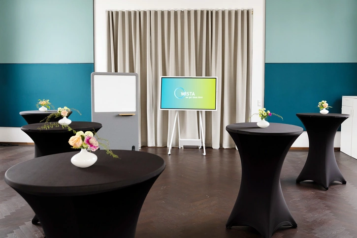 a:head area – Stehtische auf dunklem Parkett und mobile LED-Bildschirme