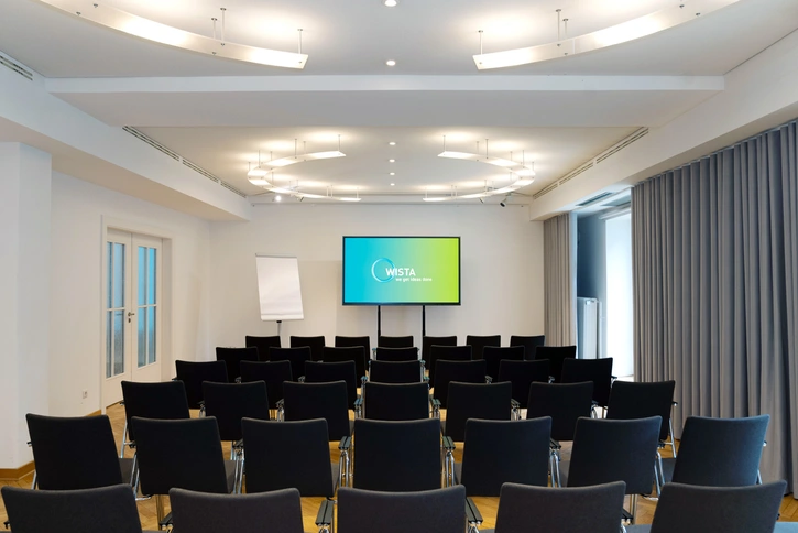 Curie-Kabinett: Kleiner Konferenzraum mit Theater-Bestuhlung und ringförmiger Beleuchtung
