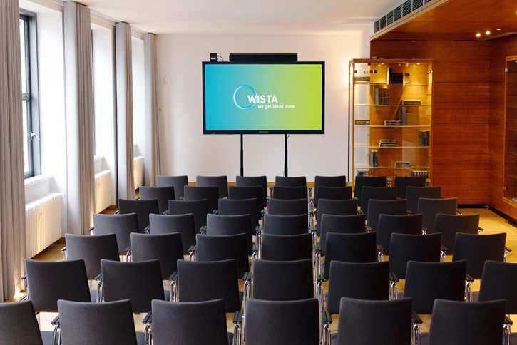Hertz-Kabinett: Konferenzraum mit Theaterbestuhlung, rechts mit dunkler Holzverkleidung und Vitrinenschrank