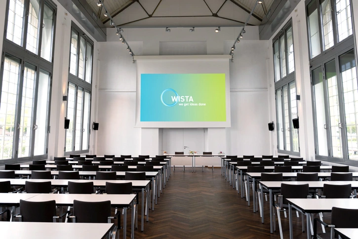 Hans-Grade-Saal: Großer Veranstaltungssaal mit hohen Fenstern und parlametarischer Bestuhlung