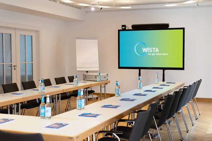 Curie-Kabinett: Kleiner Konferenzraum mit Tischen in U-Form
