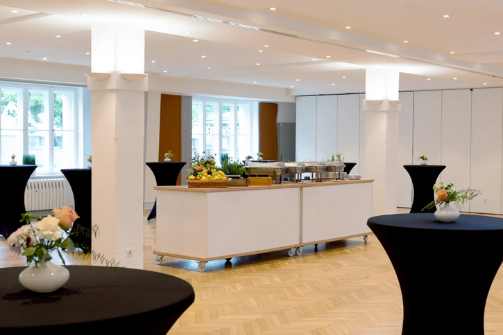 Einstein-Newton-Kabinett: Großer, heller Konferenzraum mit geschmückten Stehtischen und Catering-Angebot