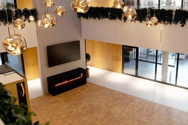 ST3AM-Arena: Innenraum mit goldenen Kugelleuchten und elektrischem Kamin